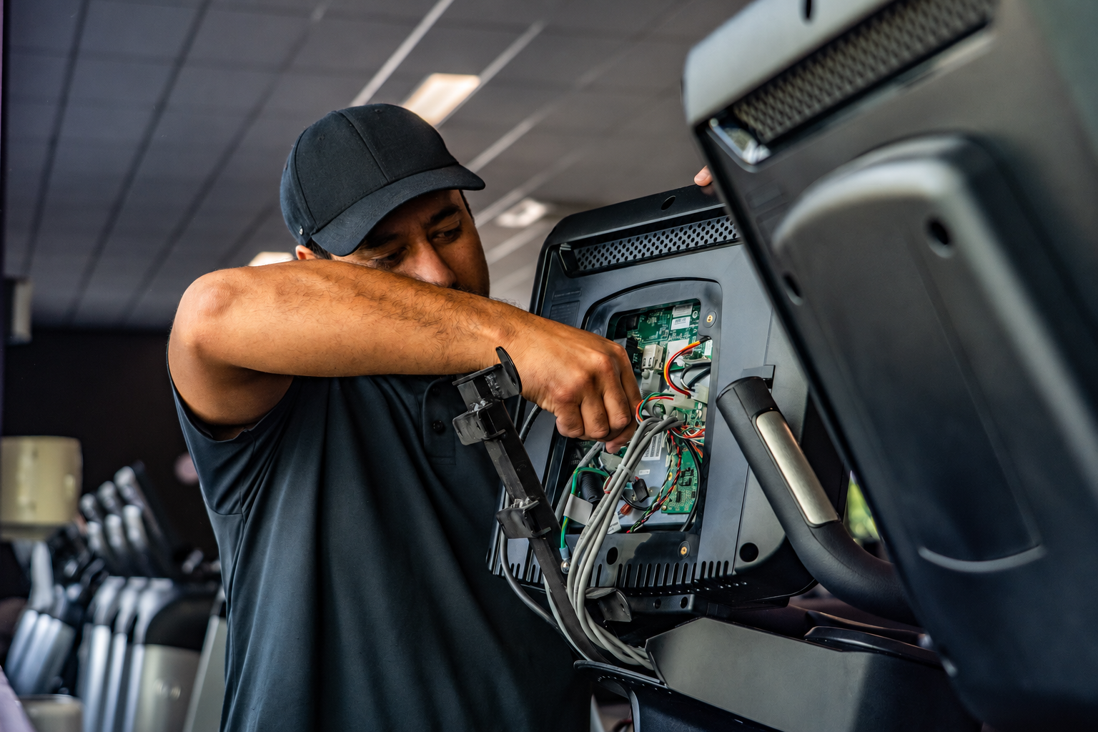 Technician repairing the console of gym equipment