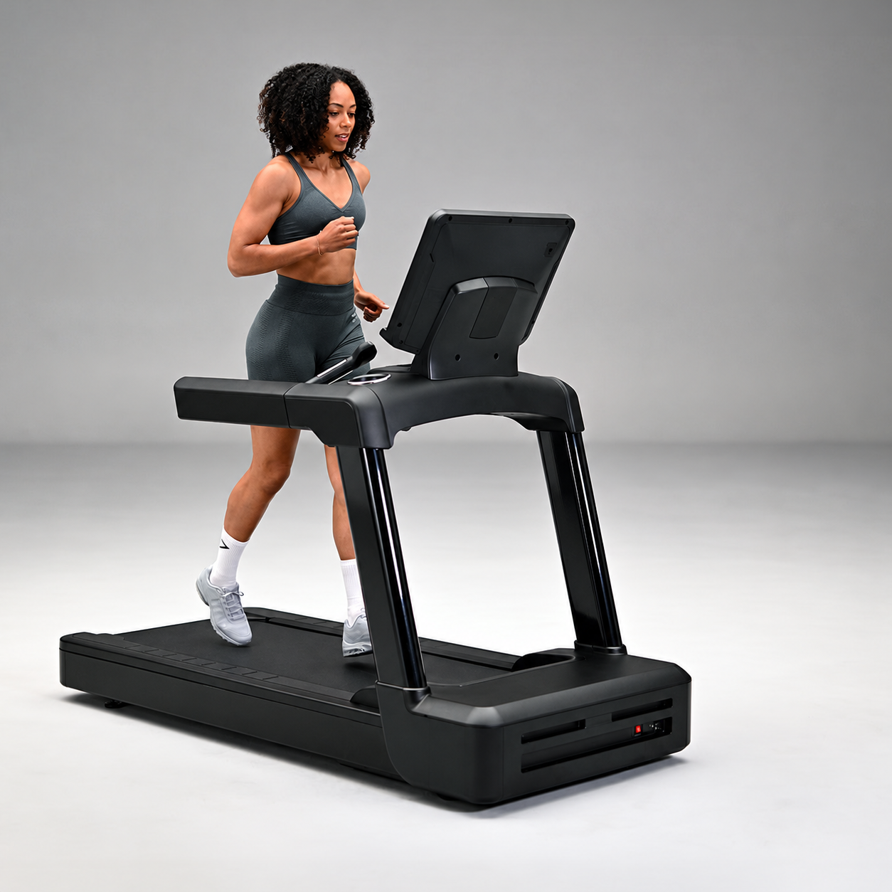 Woman running on a black commercial treadmill